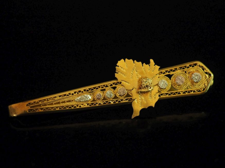Elément de châtelaine en or 750, à décor ajouré et filigrané.  H. 6,9 