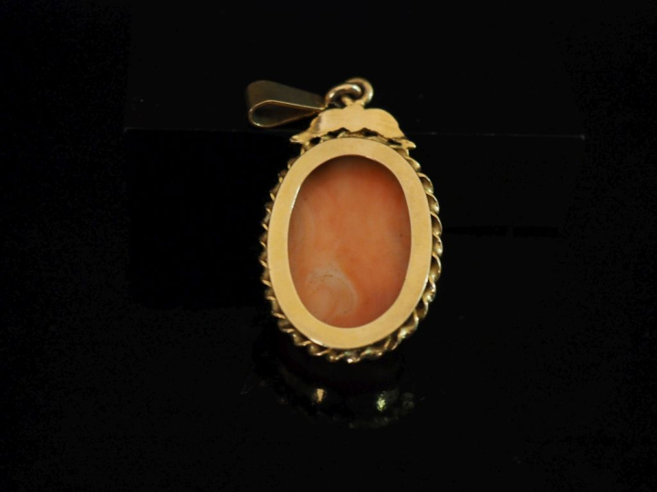 Pendentif ovale en or jaune 750, serti en son centre d'un camée corail