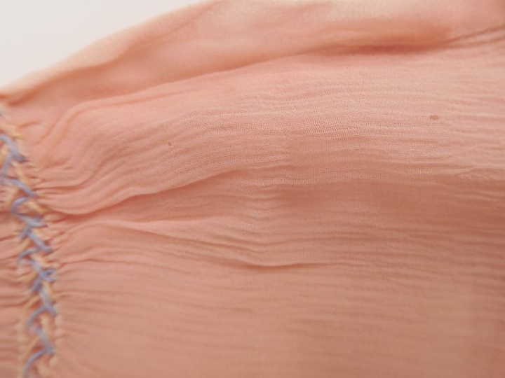 Robe en voile rose garnie points lancés bleu. Bel état d’usage, trous,