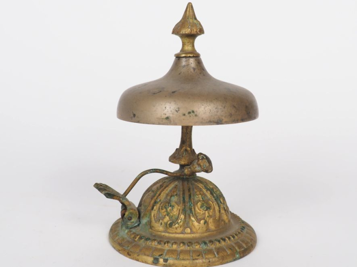 Sonnette de table 1900 en bronze à décor de frise de perles. H. 15 cm.