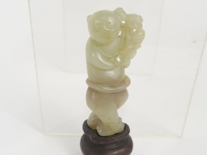 Chine. Figurine en jade d’un enfant portant une branche sur son épaule