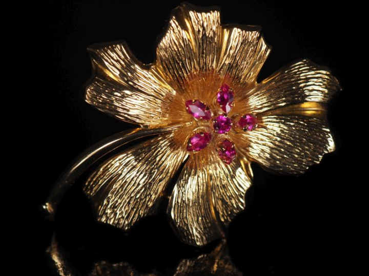 Broche en or jaune 750, en forme de fleur épanouie, sertie de petites 