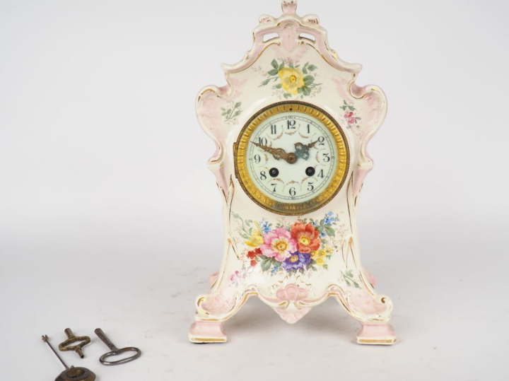 ROYAL BONN. Pendule 1900 en céramique à décor de fleurs sur fond rose.