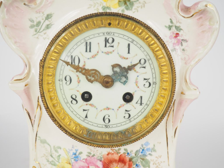 ROYAL BONN. Pendule 1900 en céramique à décor de fleurs sur fond rose.