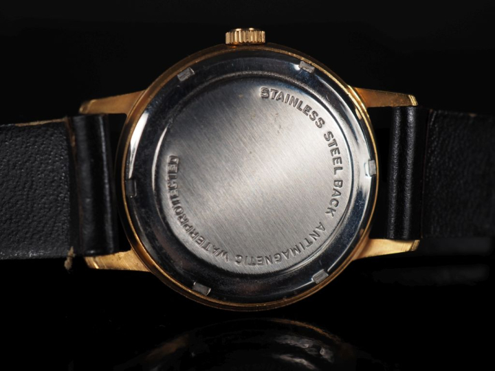 ORGUS Montre bracelet en métal doré.  Cadran rond à fond noir, chiffre