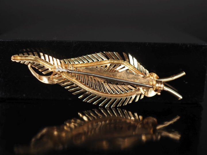 Broche en or jaune 750, en forme de feuille stylisée.  Long. 5,7 cm Po