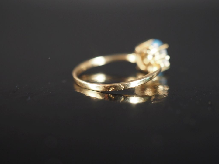 Bague en or jaune 750, sertie en son centre d'une pierre bleu ciel épa
