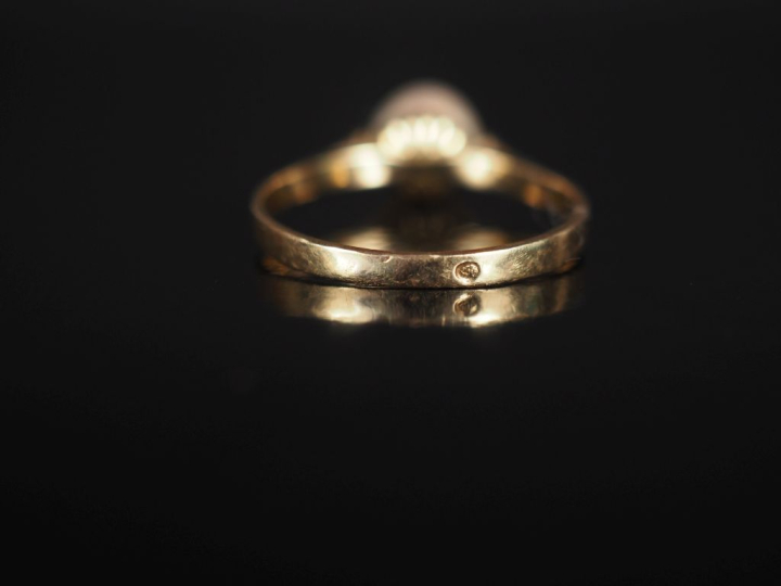 Bague en or jaune 750, sertie en son centre d'une perle blanche.  TDD.