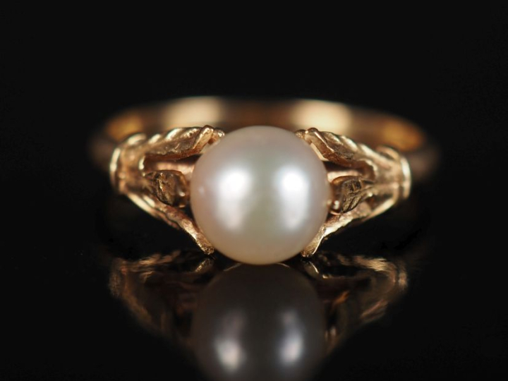 Bague en or jaune 750, sertie en son centre d'une perle blanche. Attac