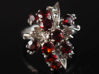 Vente aux enchères Bague à motif floral en argent, sertie de pierres rouges.  TDD. 57 Poi