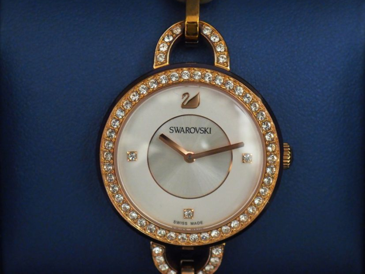 SWAROVSKI Montre bracelet de dame en métal doré, rehaussé sur le cadra