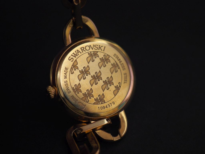 SWAROVSKI Montre bracelet de dame en métal doré, rehaussé sur le cadra