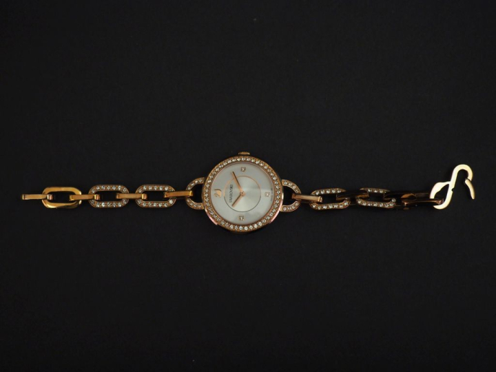 SWAROVSKI Montre bracelet de dame en métal doré, rehaussé sur le cadra