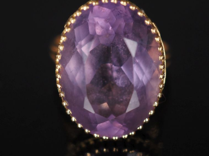 Bague en or jaune 750, sertie en son centre d'une améthyste. Jolie mon