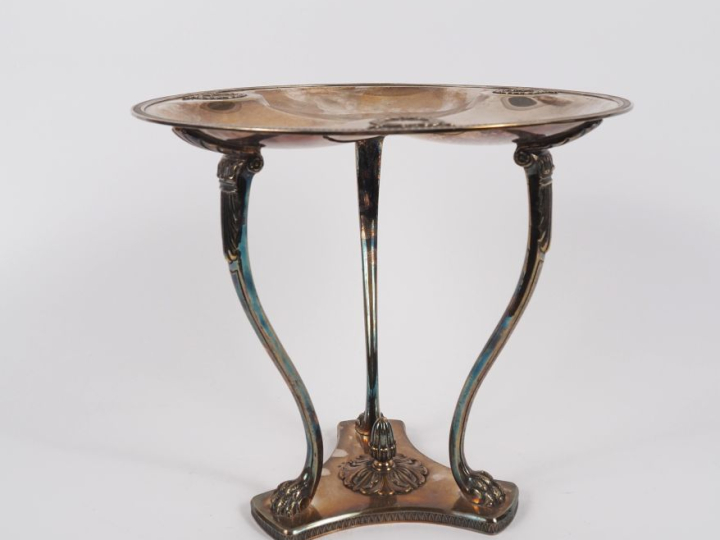 Présentoir tripode style Empire en métal argenté, pieds griffe. H. 26,