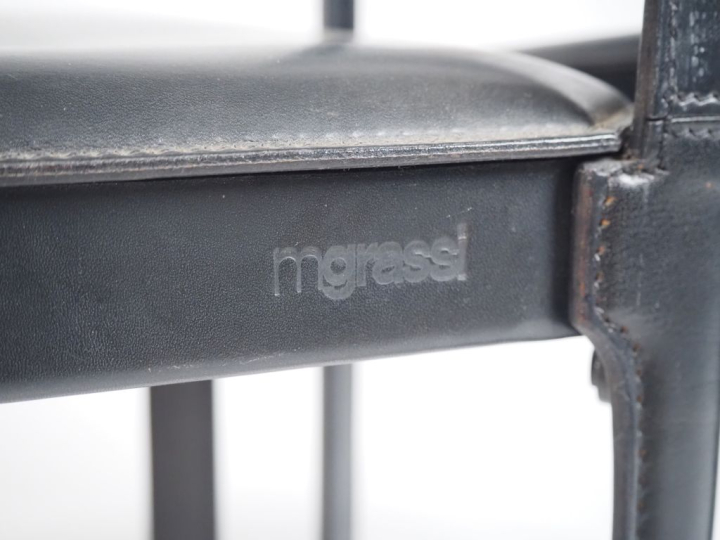 MATTEO GRASSI.  8 chaises en cuir noir. Signées. (accidents)