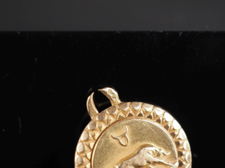 Petite médaille en or jaune 750, figurant le signe astrologique du tau