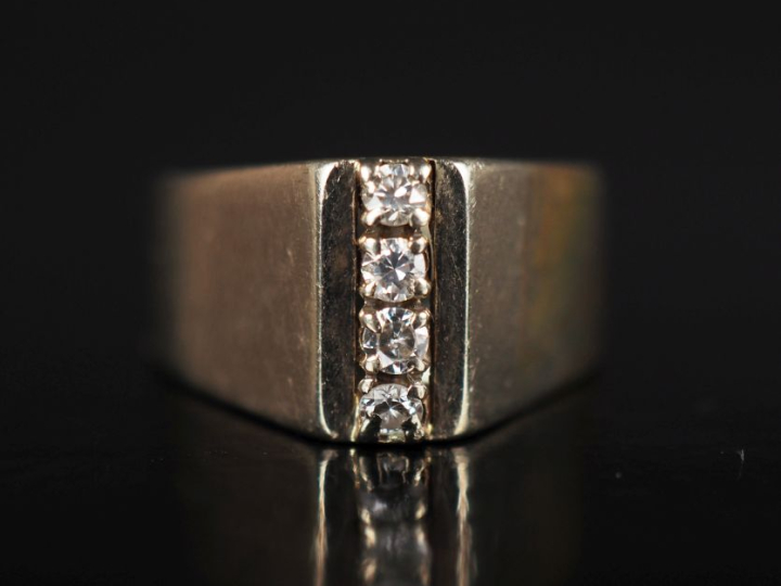 	Bague en or 750, agrémentée d'une ligne de quatre petits diamants. TD