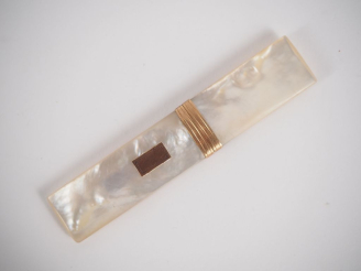 Vente aux enchères Porte aiguille 1900 en nacre et pomponne. L. 8,5 cm.