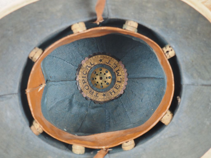 Quatre casques coloniaux.  En liège, deux recouvert de toile blanchie 