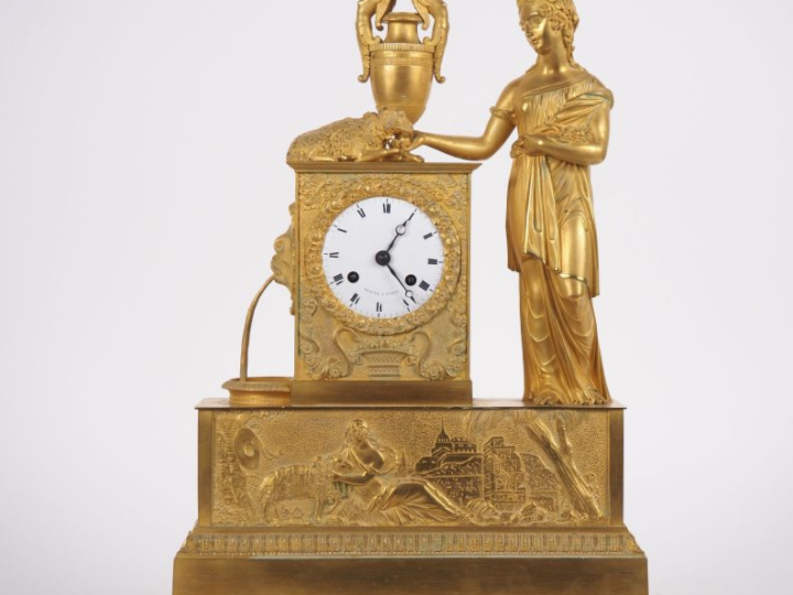Pendule Restauration en bronze doré "jeune femme à l'antique et son ag
