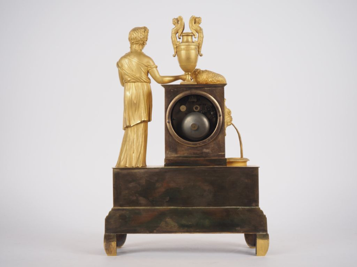 Pendule Restauration en bronze doré "jeune femme à l'antique et son ag