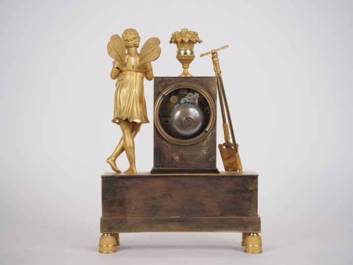 Pendule Restauration en bronze doré "allégorie de l'amour jardinier". 