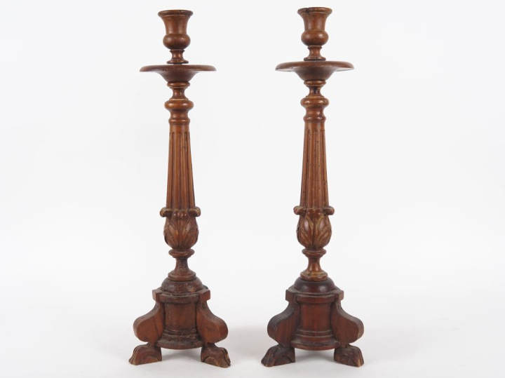 Paire de bougeoirs XIXème en bois sculpté et tourné, pieds griffe.  H.