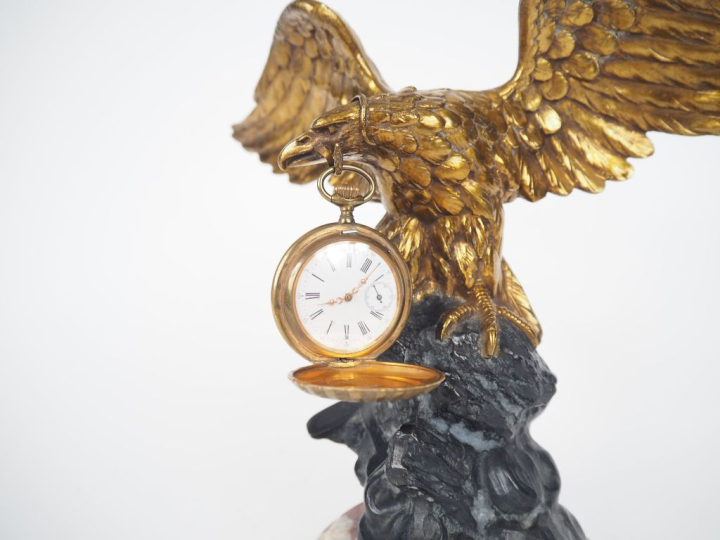 Porte montre en régule patiné et doré en forme d'aigle aux ailes déplo