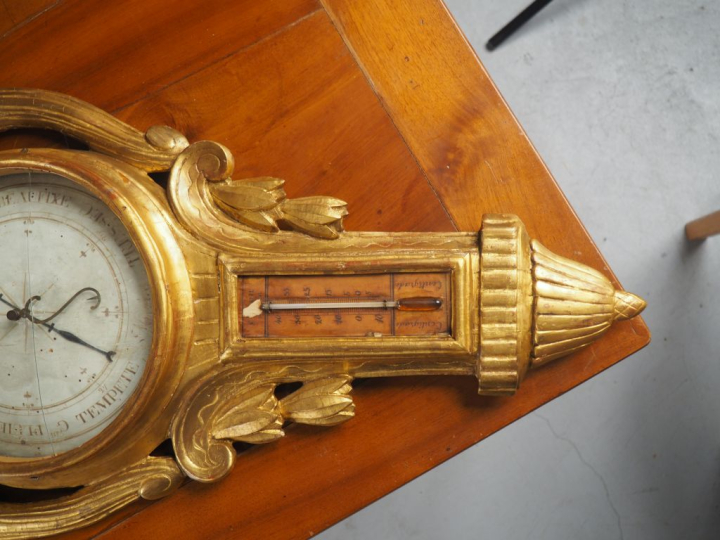 Baromètre de style Louis XVI en bois doré, à décor de vases à l’antiqu