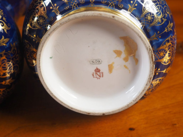 SÈVRES.  Paire de vases en porcelaine, à décor de rinceaux dorés et de