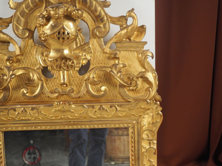 Glace Louis XV en bois sculpté et doré, à décor de rinceaux feuillagés