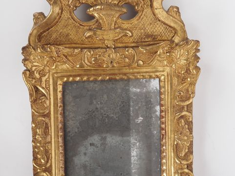 Miroir XVIIIème en bois sculpté et doré, à décor de rocailles et de fe
