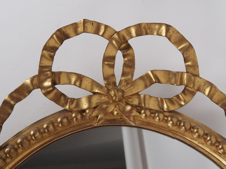 Glace médaillon de style Louis XVI, cadre en bois et stuc doré à décor