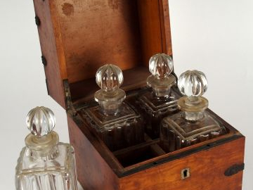 Cave à liqueur XIXème en acajou et laiton comprenant : quatre flacons 