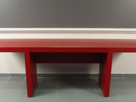 Bureau plat moderne en laque rouge.