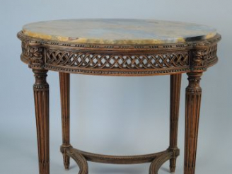 Vente aux enchères 	KRIEGER. Guéridon de style Louis XVI en bois naturel mouluré et sculp