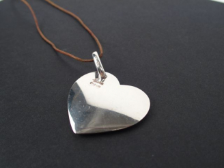 Vente aux enchères POMELLATO. Pendentif cœur dodo en argent, cordon en cuir. Dans son étu