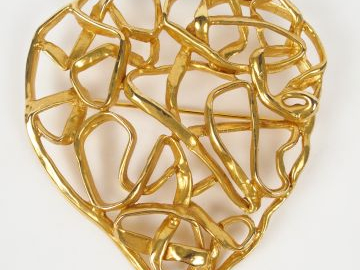 YVES SAINT LAURENT. Broche en métal doré en forme de cœur ajouré styli