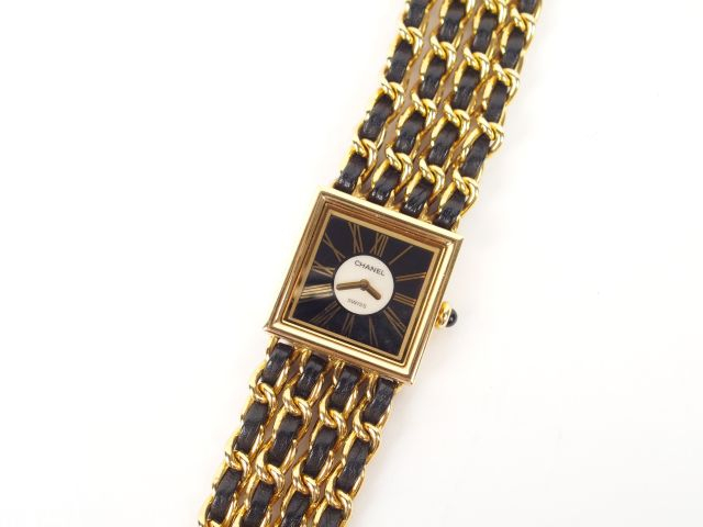 CHANEL. Montre de dame en plaqué or et 4 brins matelassage de cuir noi