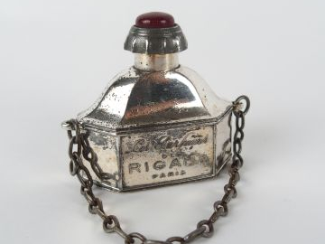 RIGAUD Flacon en métal nickelé avec chainette  Bouchon vissé orné d’un