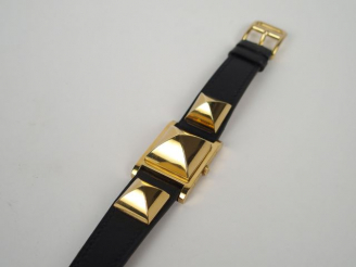 Vente aux enchères HERMES. Montre bracelet en cuir noir modèle "Médor". Certificat joint.