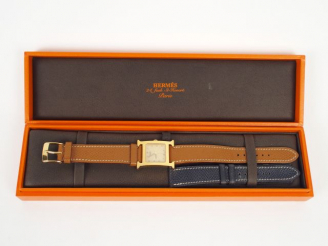 Vente aux enchères HERMES. Montre H femme, boitier or et bracelet chocolat. On y joint un