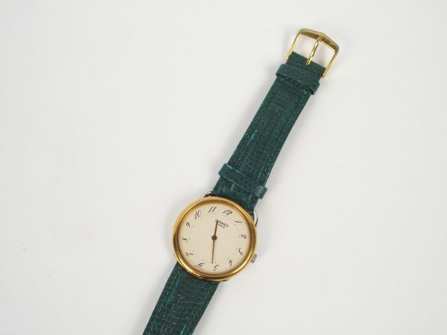 HERMES. Montre femme modèle "Arceau", boitier rond fond doré.