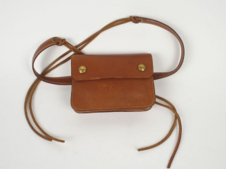 Vente aux enchères HERMES. Sac ceinture en cuir havane (usures)