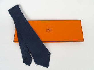 Vente aux enchères HERMES. Cravate en soie bleu marine, à décor de H