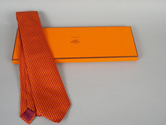 Vente aux enchères HERMES. Cravate en soie orange et bordeaux