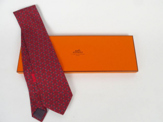 Vente aux enchères HERMES. Cravate en soie à décor stylisé rose sur fond gris