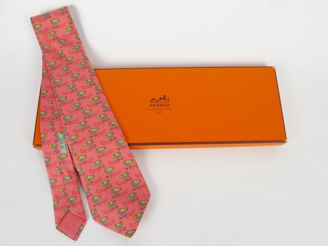 HERMES. Cravate en soie à décor de ramasseurs de riz sur fond rose. Da