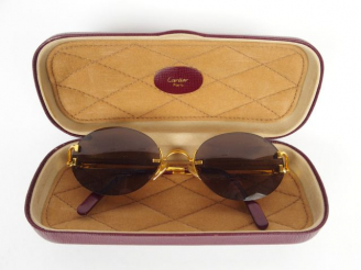 Vente aux enchères CARTIER. Paire de lunettes de soleil. Dans son écrin griffé.